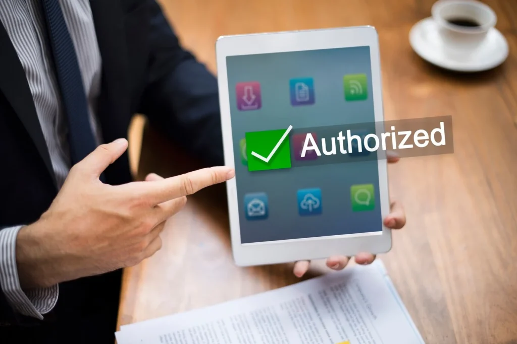 What Do Licensing Authorities Do? An image of a man pointing at an authorized app to use on a tablet